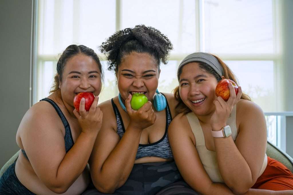 Plus-size women eating apples for their weight loss management.