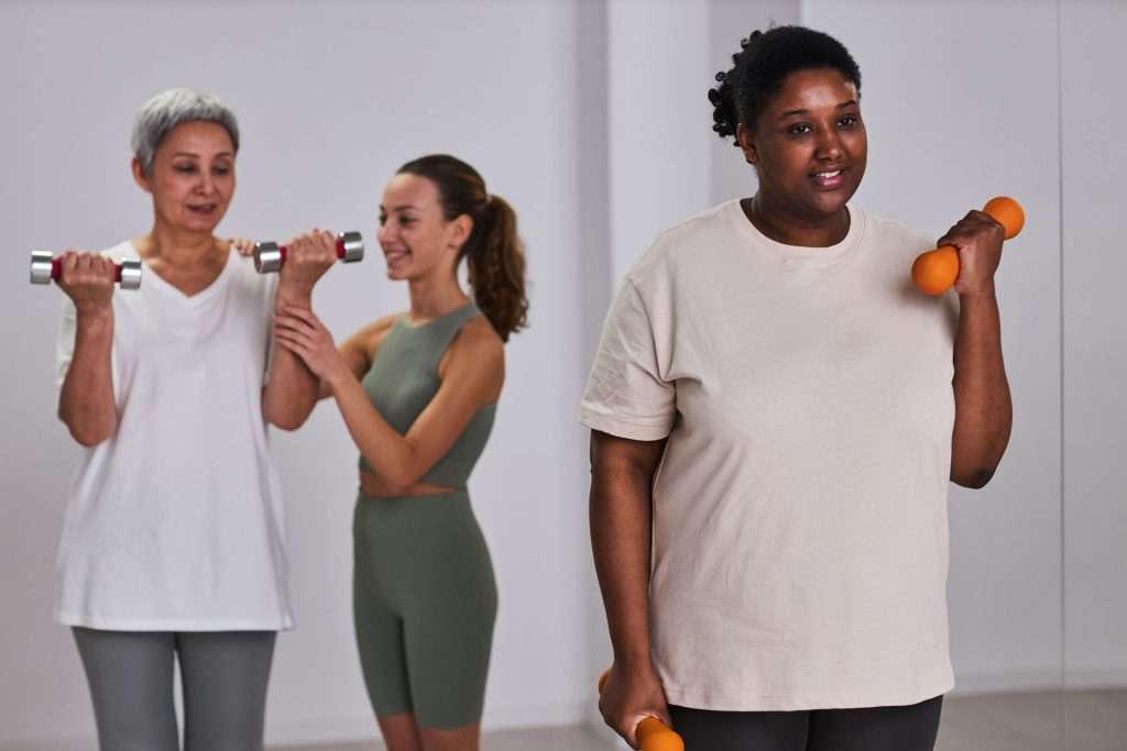 Women doing exercise with dumbbells.