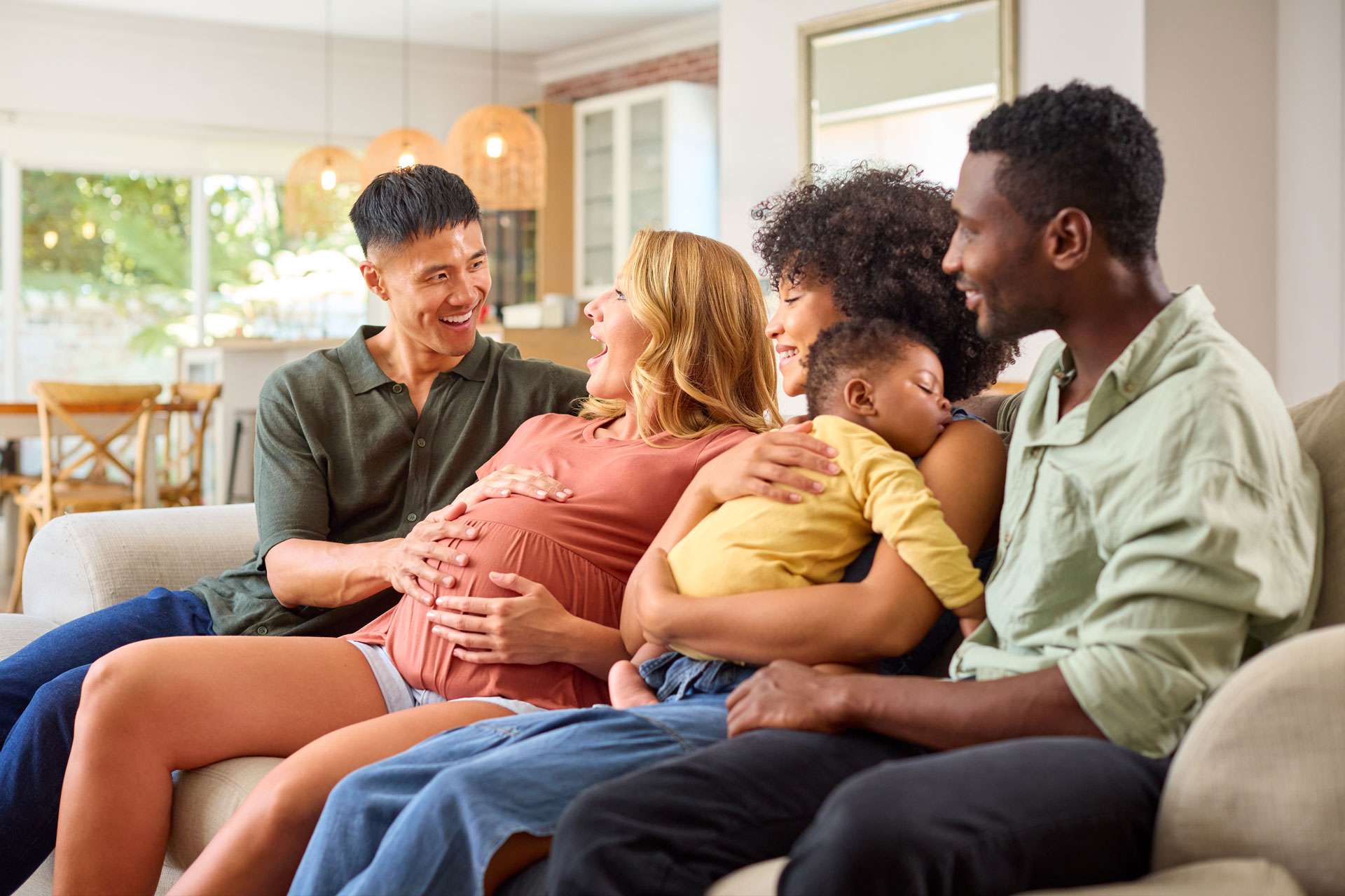 Pregnant couple together with their friends family.