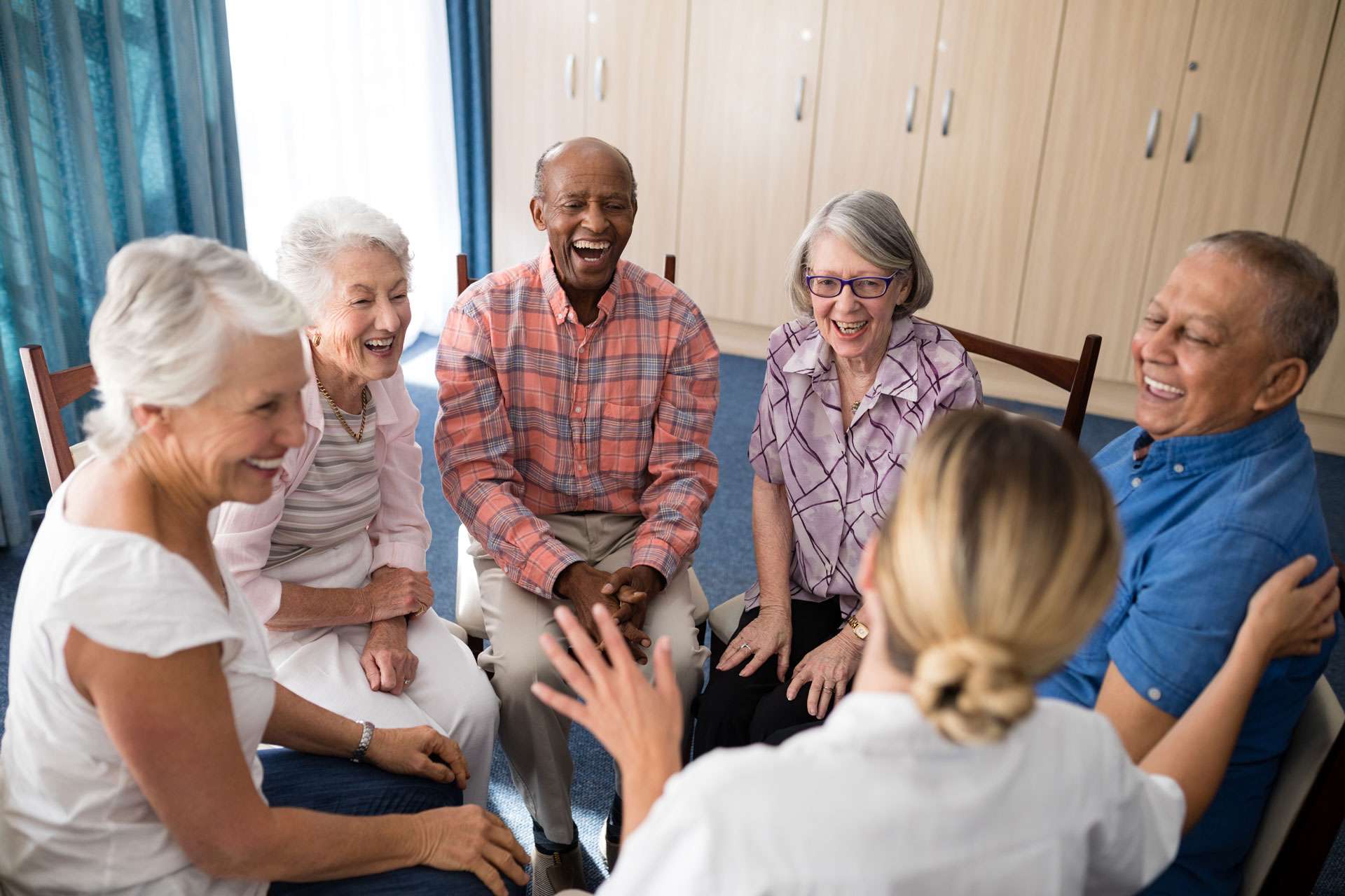 Cheerful seniors sitting with a female doctor.