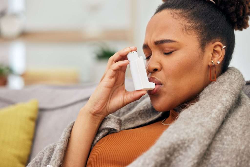 Woman using inhaler for asthma.