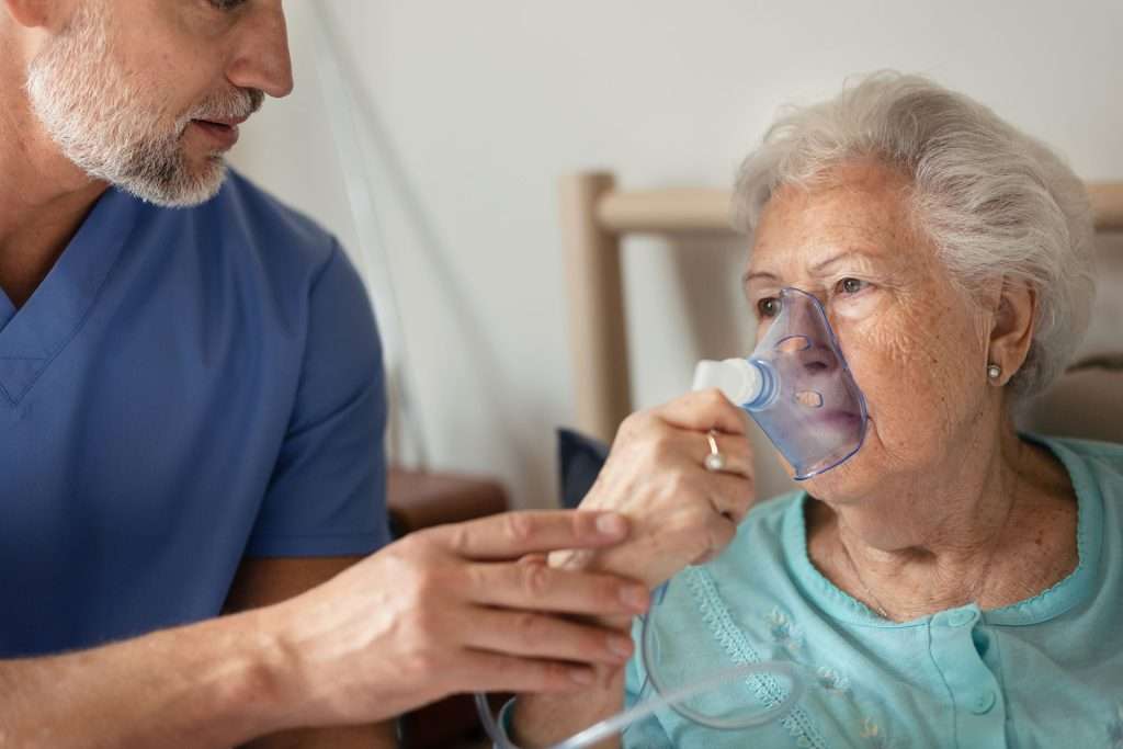 Senior woman with asthma and copd using oxygen mask.