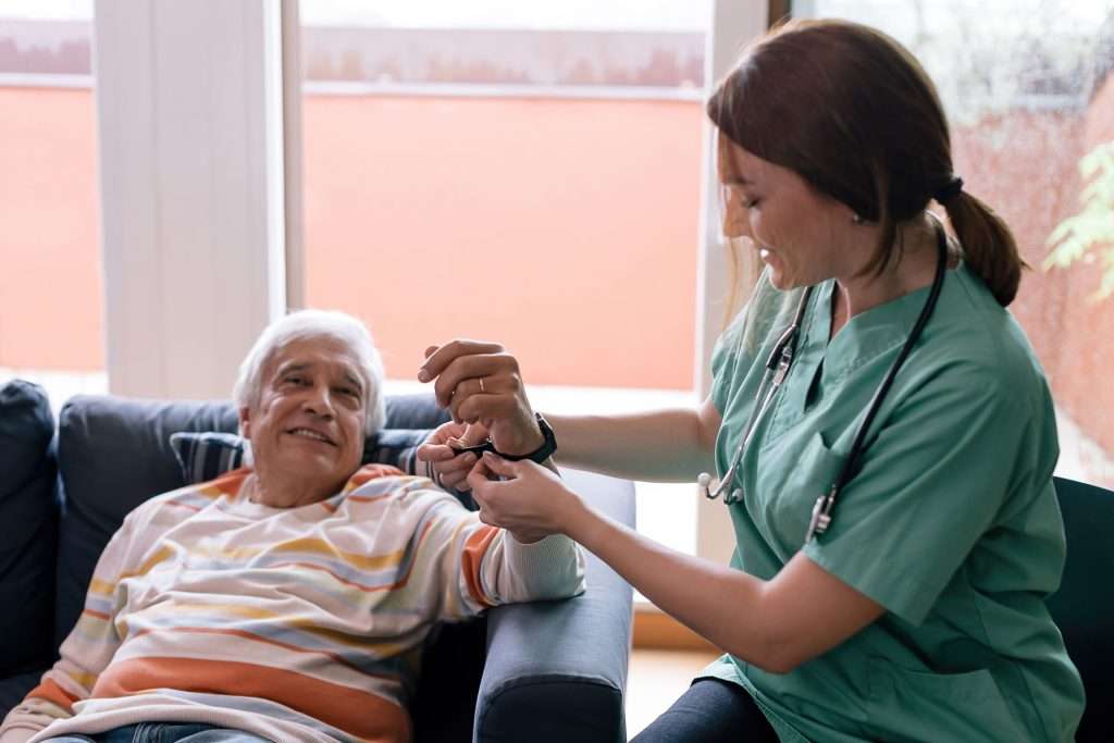 Senior man in geriatric care using a smartwatch.