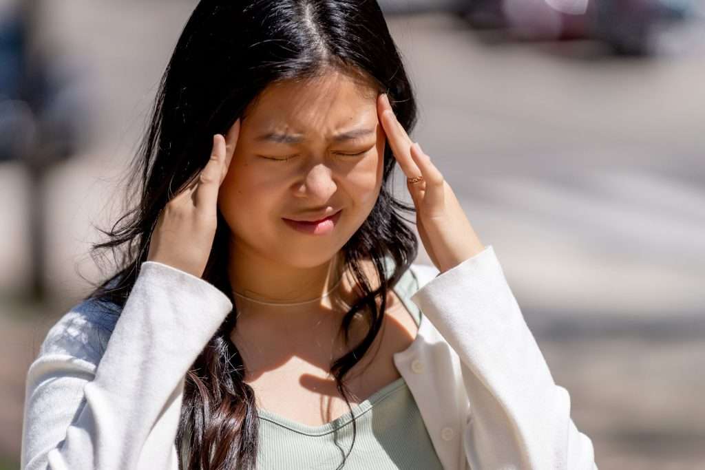 Woman with headache outdoor.