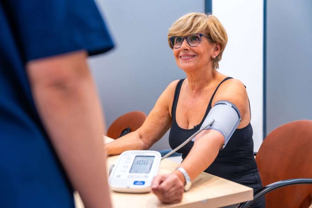 Smiling mature woman during a blood pressure check.