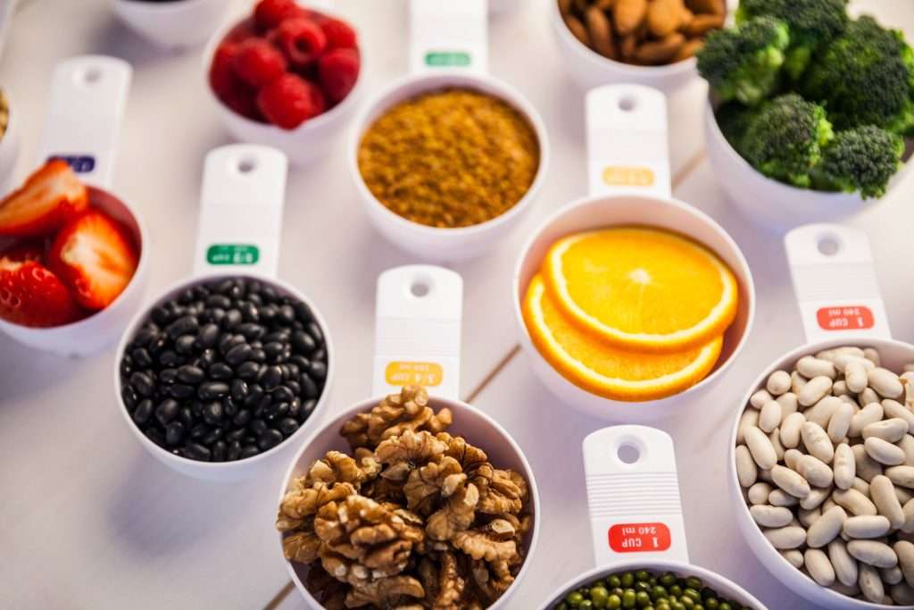 Portion cups of different healthy foods.