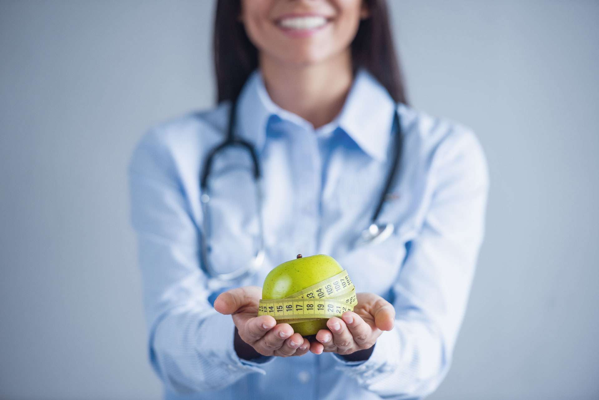 Young doctor holding an apple.