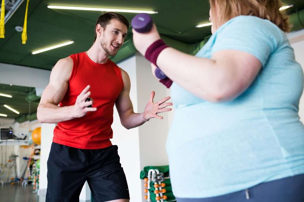 Personal trainer working with client.