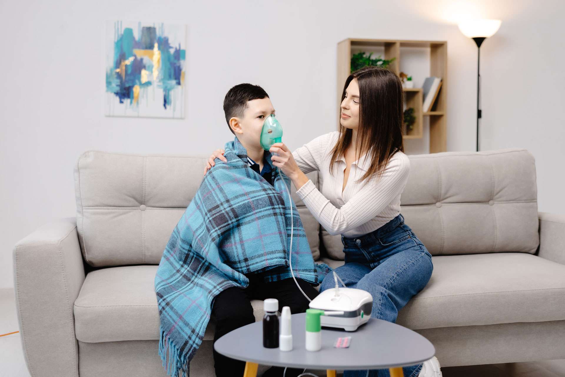 Woman helping boy with his asthma.