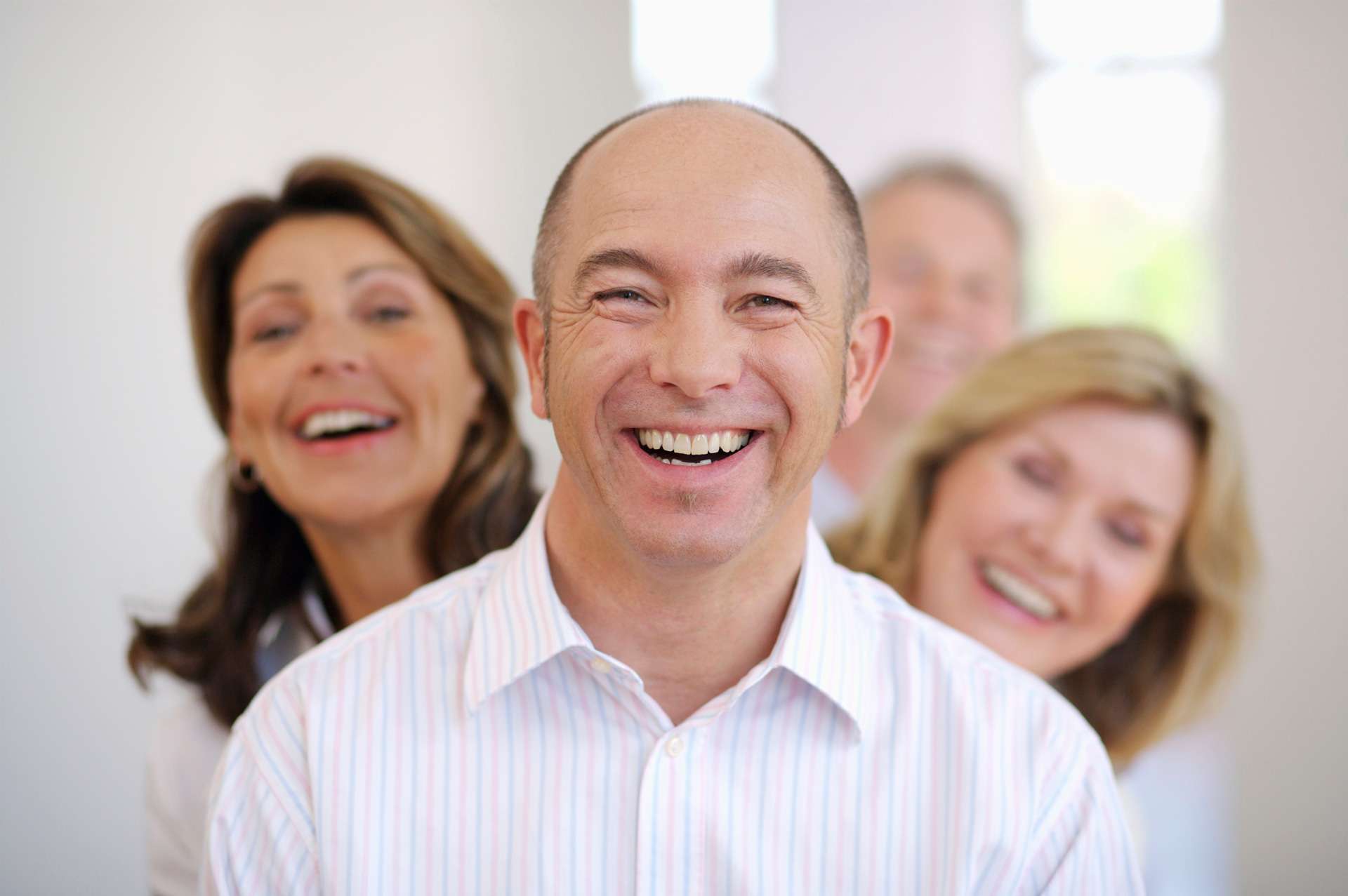 Smiling man at home with friends.