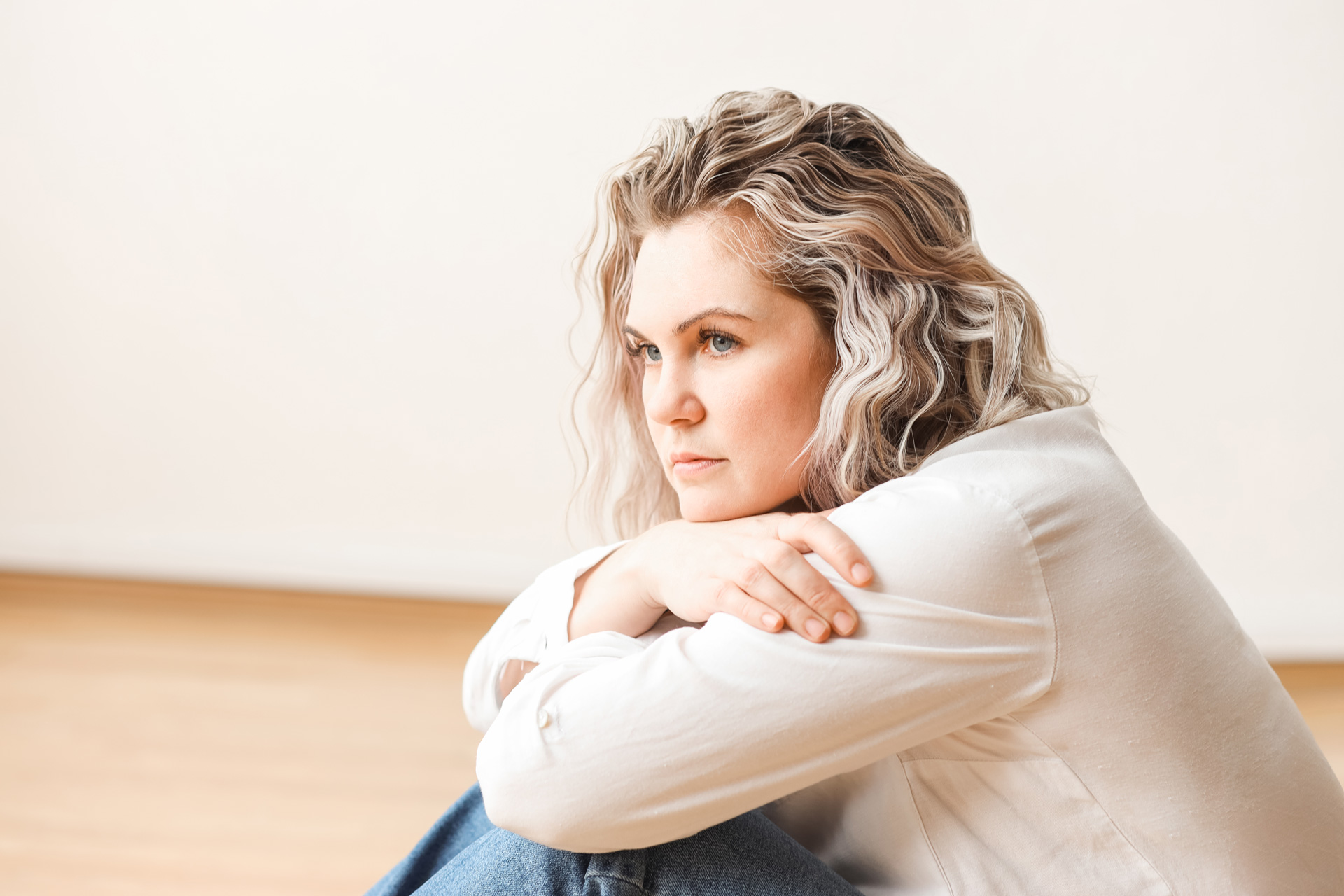 Contemplative woman with wavy hair.